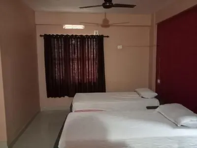 two twin beds in a room with a window at SAFA RESIDENCY in Perintalmanna