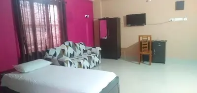 a room with a bed and chairs and a tv at SAFA RESIDENCY in Perintalmanna