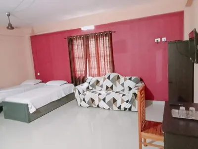 a bedroom with a bed and a chair in a room at SAFA RESIDENCY in Perintalmanna