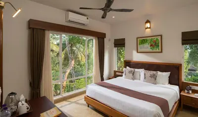 a bedroom with a bed and a large window at Jeevess Retreat Wayanad in Wayanad