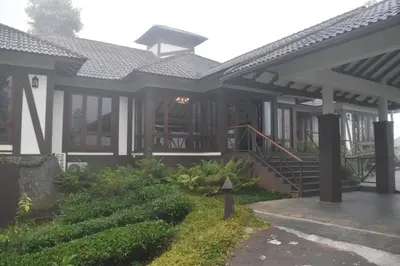 a house with a porch and a staircase at Jeevess Retreat Wayanad in Wayanad