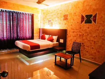 a bedroom with a bed and a chair in a room at Rambler Garden Resort in Idukki