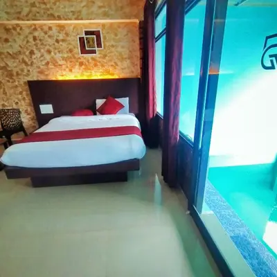 a bedroom with a bed with red pillows at Rambler Garden Resort in Idukki