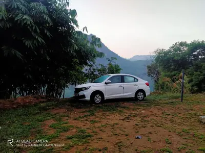 a white car parked on the side of a hill at Rambler Garden Resort in Idukki