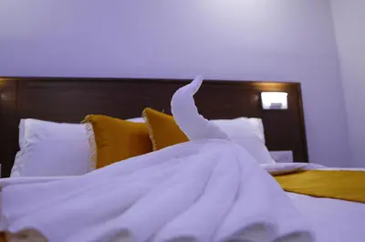 a white blanket on top of a bed at AP Residency in Wayanad