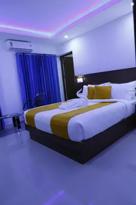 a bedroom with a large bed with blue curtains at AP Residency in Wayanad