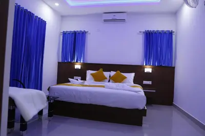 a bedroom with a large bed with blue curtains at AP Residency in Wayanad
