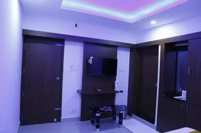 a room with a tv and some wooden doors at AP Residency in Wayanad