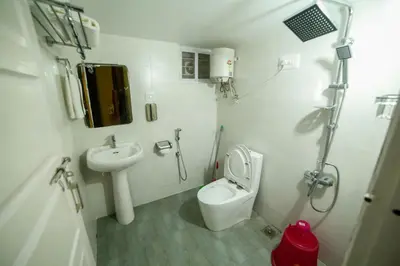 a small bathroom with a toilet and a sink at Belljem Homes -your own private resort -1 BR in Trichūr