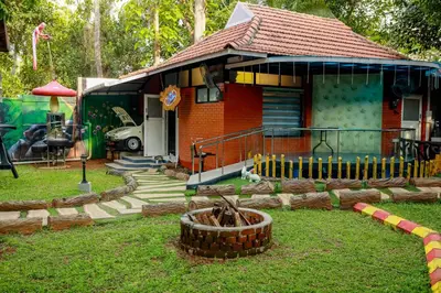 a small red house with a playground in front of it at Belljem Homes -your own private resort -1 BR in Trichūr