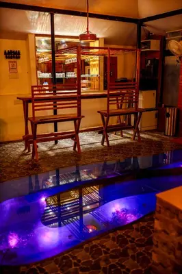 two benches sitting next to a swimming pool at night at Belljem Homes -your own private resort -1 BR in Trichūr