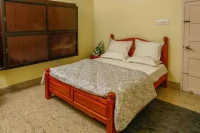 a bedroom with a large wooden bed with white pillows at Belljem Homes -your own private resort -6 BHK B in Trichūr