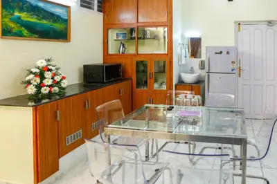 a kitchen with a glass table and chairs at Belljem Homes -your own private resort -5 BHK in Trichūr