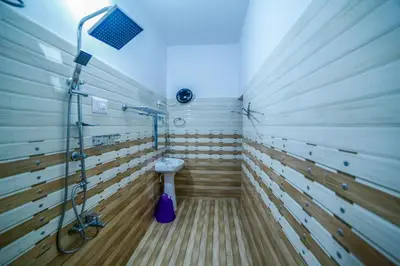 a bathroom with a shower and a toilet in it at Belljem Homes -your own private resort -5 BHK in Trichūr