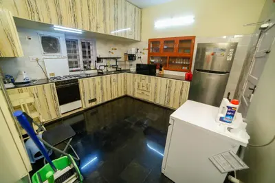 a kitchen with wooden cabinets and stainless steel appliances at Belljem Homes -your own private resort -5 BHK in Trichūr