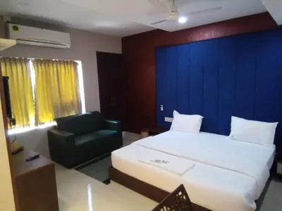 a hotel room with a bed and a chair at GRACE RESIDENCY in Tirūr