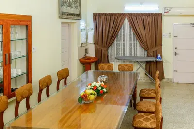 a dining room with a wooden table and chairs at Belljem Homes -your own private resort -2 BHK GF in Trichūr