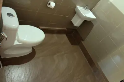 a bathroom with a white toilet and a sink at Entire Villa at the Heart of the Wayanad Forest. in Kutta