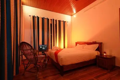 a bedroom with a bed and a chair and a window at Entire Villa at the Heart of the Wayanad Forest. in Kutta