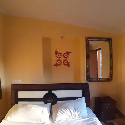 a bedroom with a bed with a mirror and a bed sidx sidx sidx at MAGIC MIST RESORT in Ooty