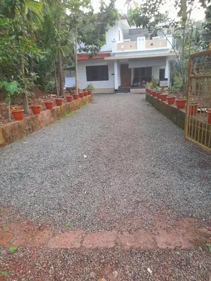 a driveway with a house in the background at Oceangreen cottage in Kannur