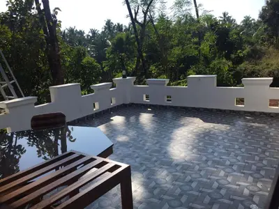 a patio with a white fence and a bench at Oceangreen cottage in Kannur