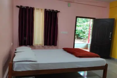 a bedroom with a bed and a window with curtains at Lake View Homestay by StayApart in Madikeri