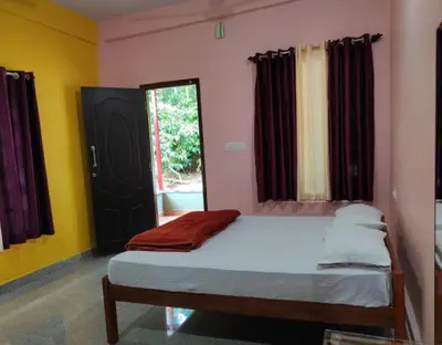a bedroom with a bed and a window at Lake View Homestay by StayApart in Madikeri