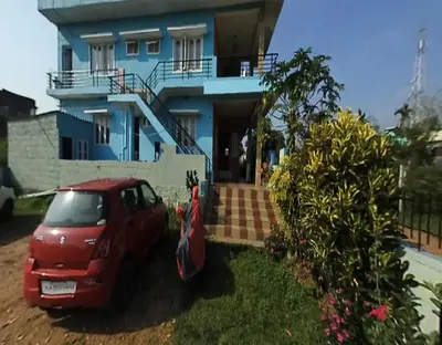 a red car parked in front of a house at Coorg Dream Land Homestay by StayApart, Kushalnagar in Kushālnagar