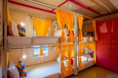 a bedroom with two bunk beds with orange curtains at goSTOPS Coorg in Madikeri