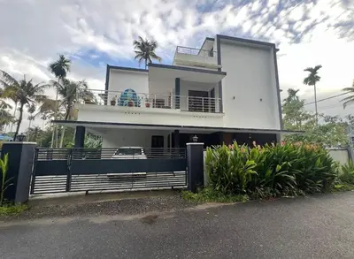 a white house with a balcony and palm trees at Bachan's Casa The Private Pool Villa Cherai in Cherai Beach