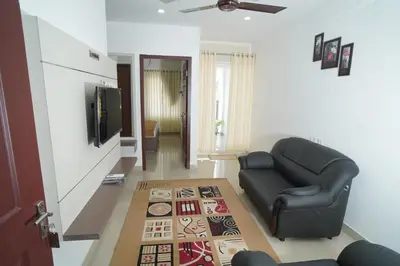 a living room with a couch and a television at SN ROOMS in Perumbavoor