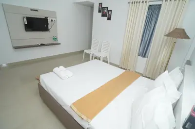 a bedroom with a bed with a mirror and a tv at SN ROOMS in Perumbavoor
