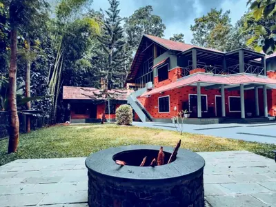 a fire pit in front of a house at Adrak Mountain Mist Forest Resort in Pulpally