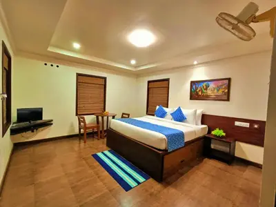 a bedroom with a bed and a desk and a television at Adrak Mountain Mist Forest Resort in Pulpally