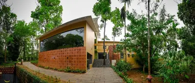 a yellow house with a stone walkway in front of it at Maple Ash Resort in Vayittiri