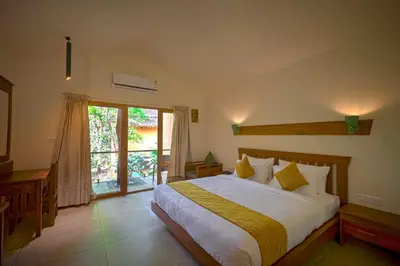 a bedroom with a large bed and a sliding glass door at Maple Ash Resort in Vayittiri