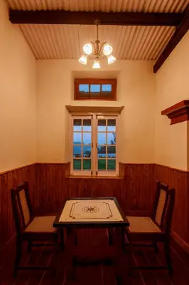 a room with a table and two chairs and a window at Rosewood by Nature Resorts and Stays in Ooty