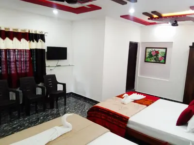 a hotel room with two beds and a theater at Leo's Residency Coorg in Kushālnagar