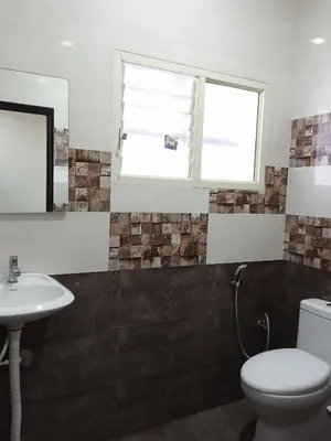 a bathroom with a toilet and a sink at Leo's Residency Coorg in Kushālnagar