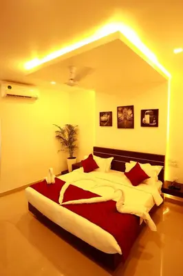 a large bedroom with a large bed with red pillows at ORFILA INN Airport Hotel in Angamali