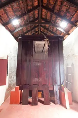 a room with a wooden wall with chairs in it at Sardar Bahadur's Heritage Bungalow Estate Stay in Napoklu