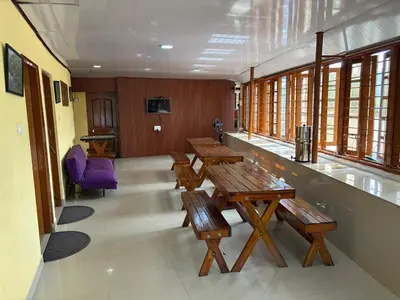 a row of benches in a waiting room with windows at Honeybee Homestay by The Jungle Stay Groups in Vālpārai
