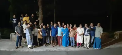 a group of people posing for a picture at night at Honeybee Homestay by The Jungle Stay Groups in Vālpārai