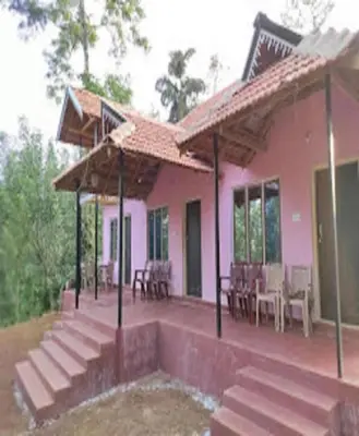 a pink house with stairs and a patio at Green Coorg by StayApart, Madikeri in Madikeri