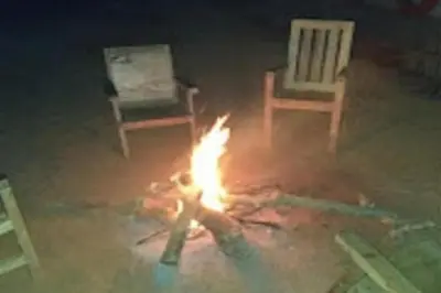 a fire in the middle of two chairs and two fires at Green Coorg by StayApart, Madikeri in Madikeri
