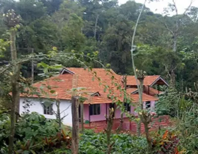 a house with an orange roof in the forest at Green Coorg by StayApart, Madikeri in Madikeri
