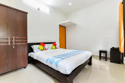 a bedroom with a large bed and a wooden cabinet at CentreHome Villa Wayanad in Meenangadi