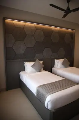 two beds sitting next to each other in a room at RATHNA RESIDENCY in Coimbatore