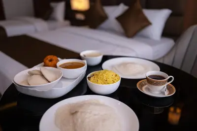 a table with bowls of food and cups of coffee at MEDLEY REGENCY in Palakkad